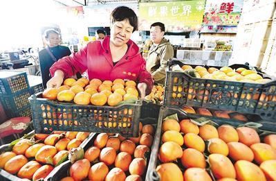日前,市果品批發(fā)市場扶貧館專賣區(qū)的商戶在整理果品.